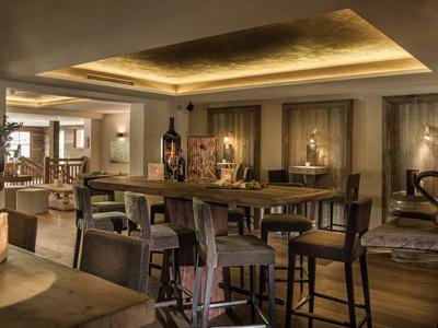 Acogedora zona de bar en hotel con muebles de madera oscura y luz cálida y suave.