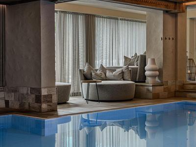 Piscina moderna de hotel con áreas de descanso cómodas y ambiente cálido y acogedor.