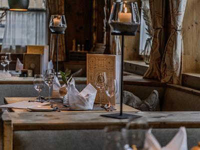 Área de comedor acogedora en un restaurante con mesas preparadas y luz cálida.