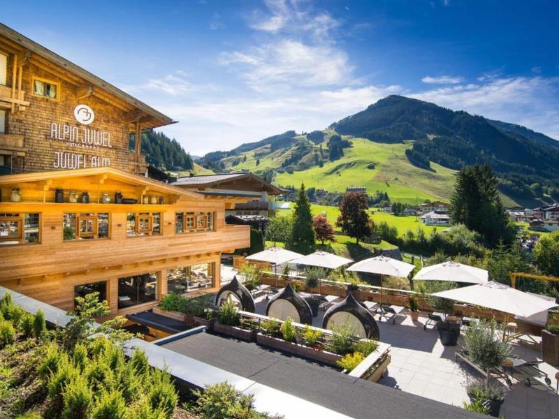 Hotel con terrazza solarium, vista sulle montagne e fusione di architettura in legno e natura.