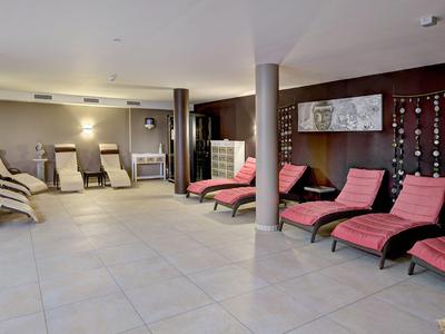 Innenansicht eines Ruhebereichs mit mehreren Liegen und gedämpfter Beleuchtung.