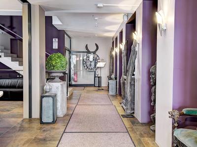 Flur mit violetten Wänden, Teppichläufer, Dekorationsobjekten und Sitzgelegenheiten.