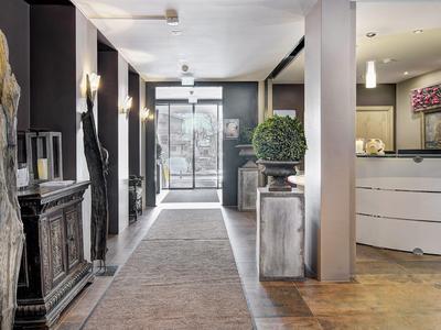 Eleganter Hotel-Flur mit bodentiefen Fenstern und stilvoller Dekoration