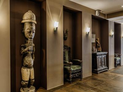 Hallway with decorative wooden sculptures and antique furniture in a hotel.