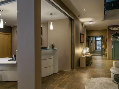 Modern hotel lobby with beige flooring, seating areas, and warm lighting.