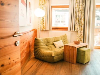 Gemütliche Sitzecke mit grünem Sessel, Holztisch und Fenster mit Ausblick.