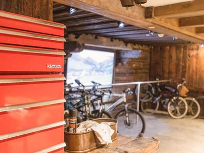 Rotes Werkzeugschrank neben mehreren Fahrrädern in einer rustikalen Holzgarage.
