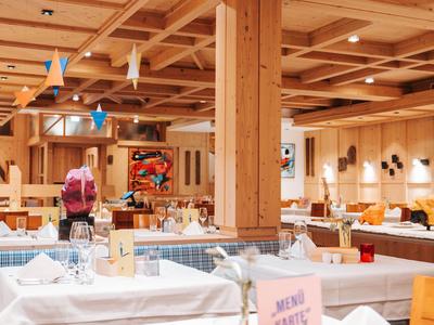 Gemütliches Restaurant mit Holzmöbeln und festlich gedeckten Tischen.