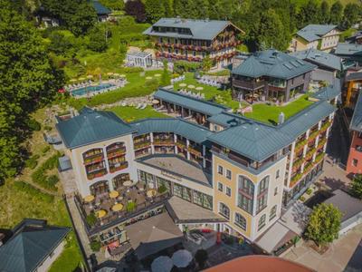 Vista aérea de un complejo hotelero moderno con varios edificios, jardines verdes y espacios exteriores.