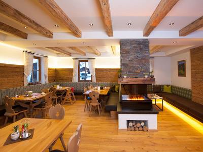 Gemütliches Restaurant mit Holzbalken, moderner Beleuchtung und Kamin