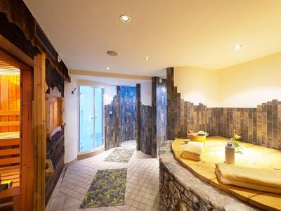 Moderner Wellnessbereich mit Sauna und Whirlpool in warmem Licht