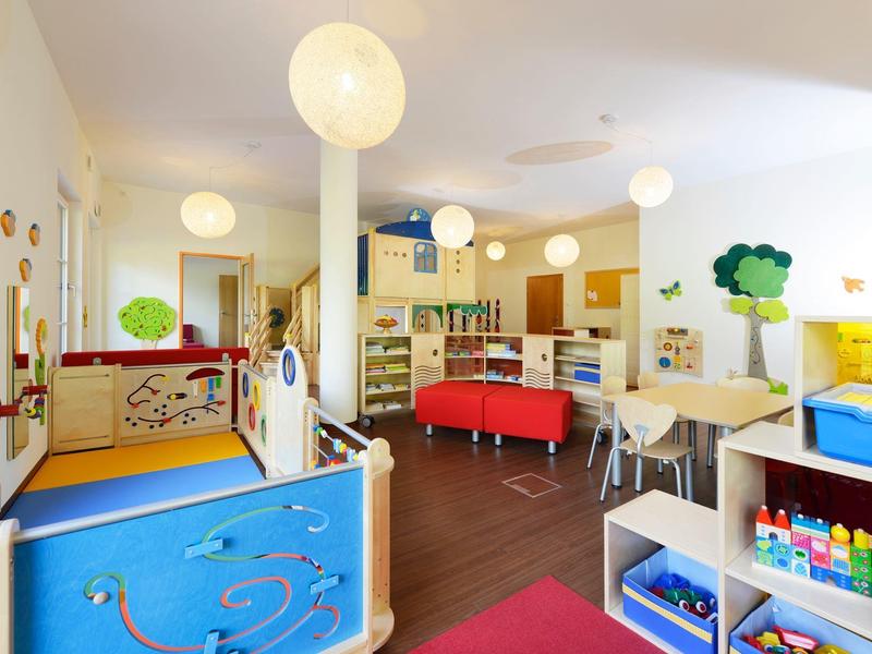 Helle und farbenfrohe Kinderspielecke in einem Hotel mit Spielzeug und Sitzgelegenheiten.