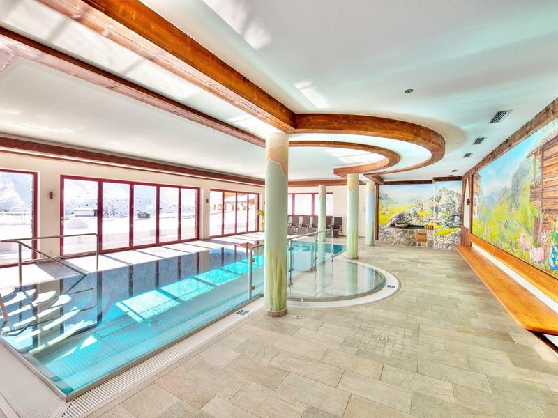 Moderner Innenpoolbereich mit großen Fenstern und Holzverkleidung in einem Hotel.