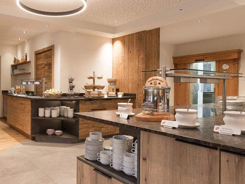 Buffetbereich mit Holztheken und Besteck in einem hellen Hotelrestaurant.