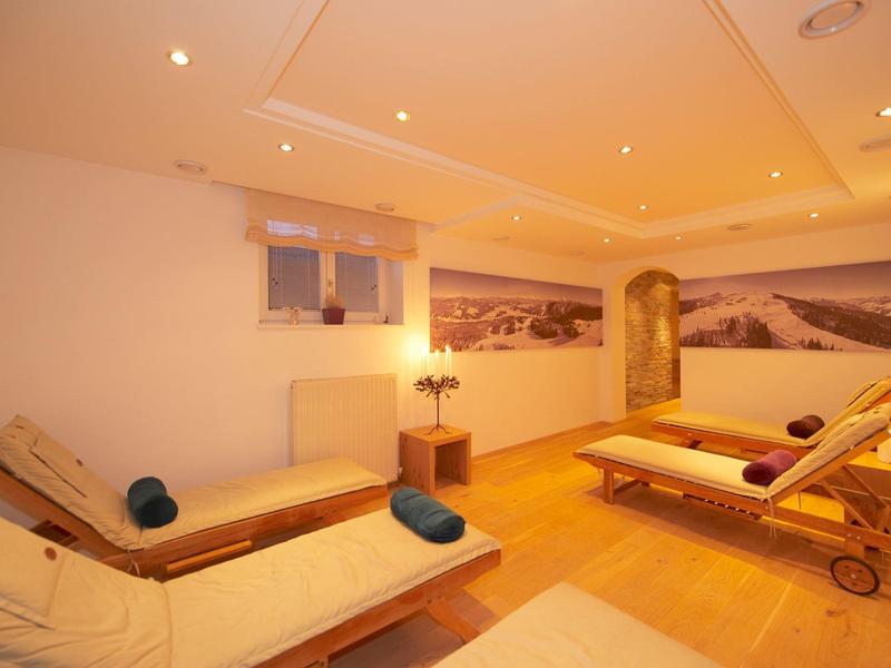 Helles Wellnesszimmer mit zwei Liegen, warmem Holzfußboden und beruhigender Wandkunst.