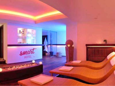 Moderne Hotellobby mit buntem Licht, Empfangstresen und gemütlichen, geschwungenen Liegen.