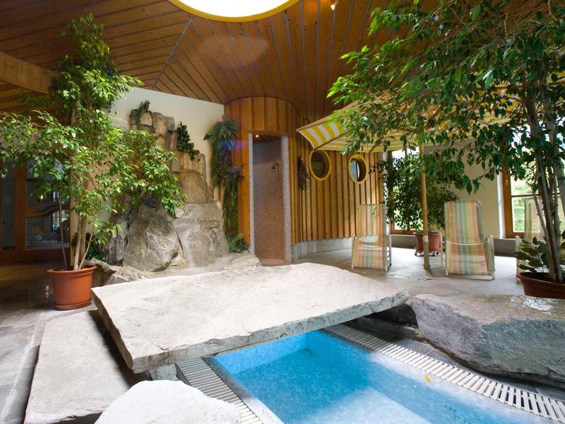 Espace spa intérieur avec rochers, plantes et éléments en bois dans un hôtel