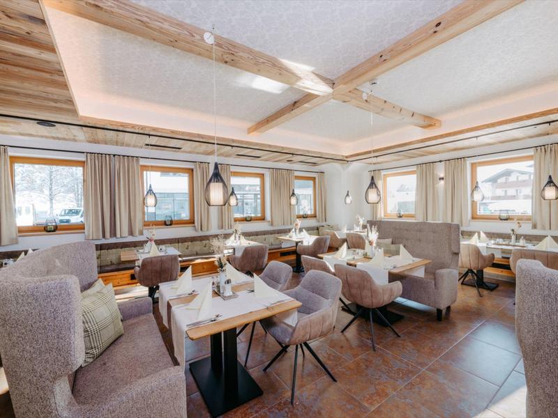 Jasna, przytulna jadalnia z drewnianymi akcentami i wygodnymi krzesłami w hotelu.