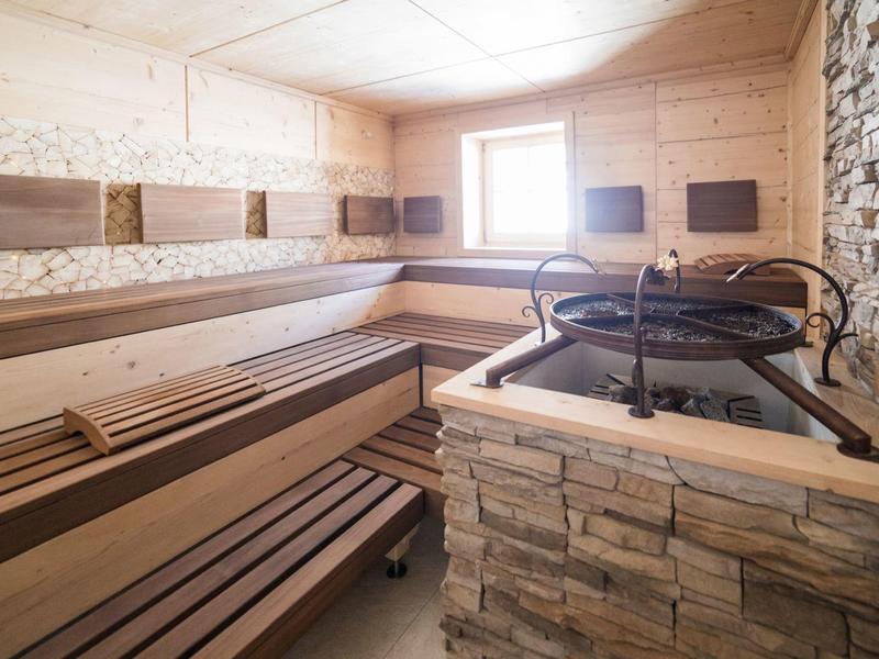 Pohodlná sauna s dřevěným interiérem a kamenným kamenem v wellness oblasti.