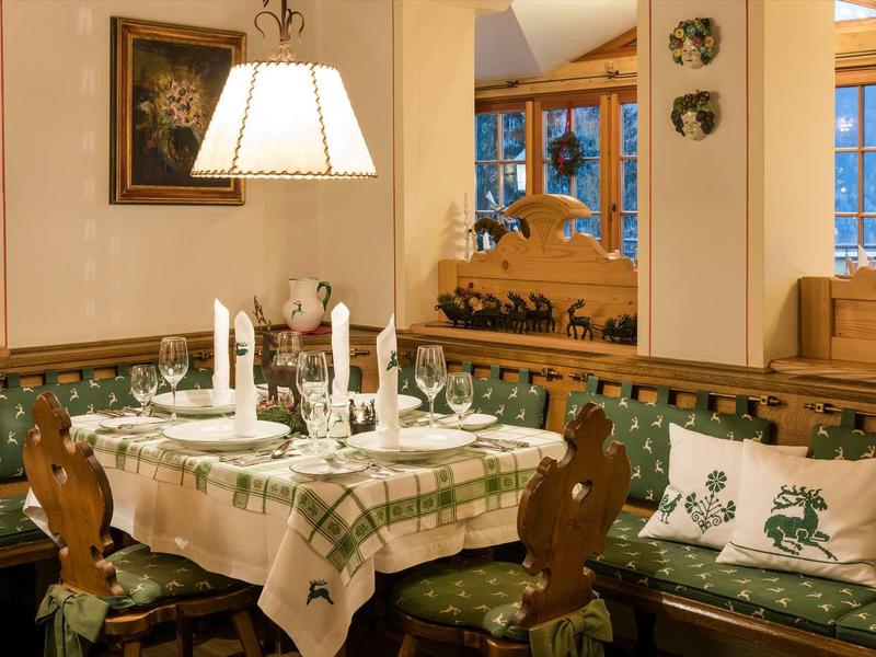 Coin repas confortable avec meubles en bois, nappe à carreaux et coussins décoratifs.