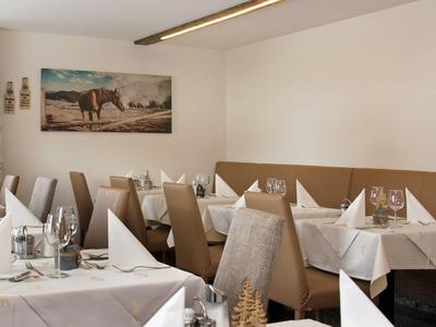 Salle à manger élégante avec tables dressées et décoration murale.