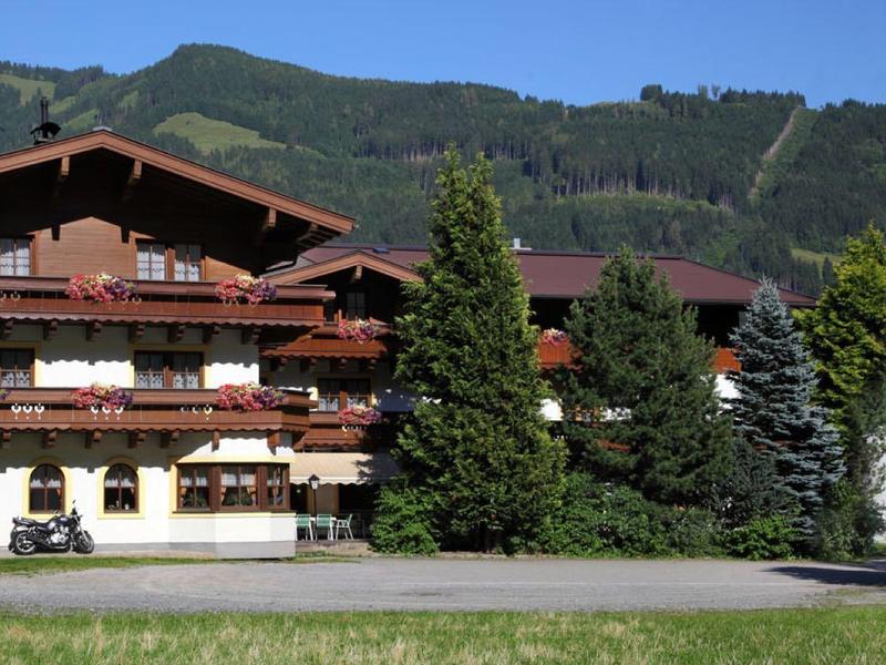 Hôtel chalet traditionnel avec revêtement en bois et balcons dans un cadre montagneux pittoresque.