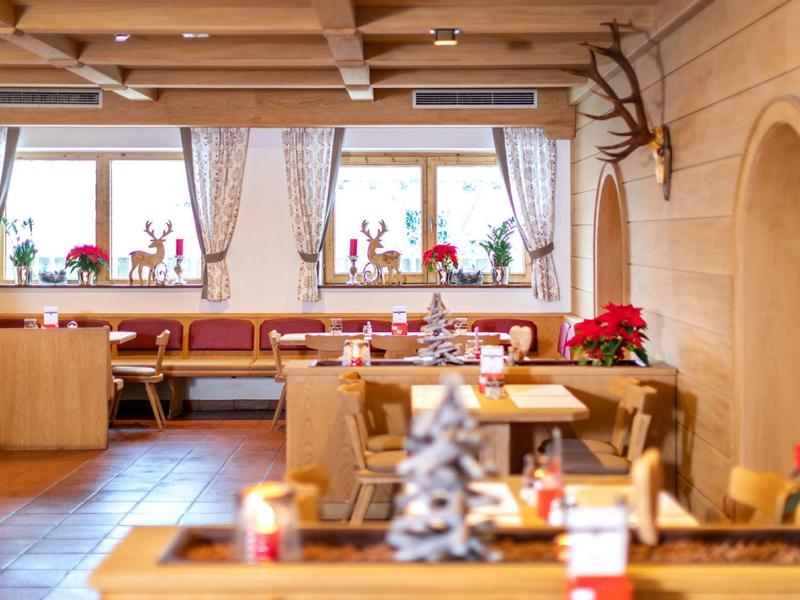 Salle à manger d'hôtel chaleureuse avec boiseries et décorations festives.