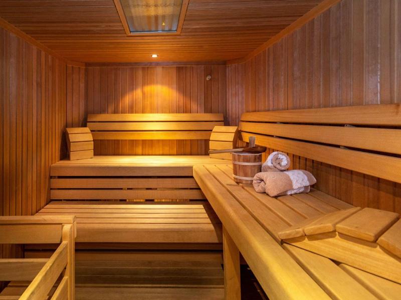 Sauna en bois avec bancs à plusieurs niveaux et serviettes sur le banc.