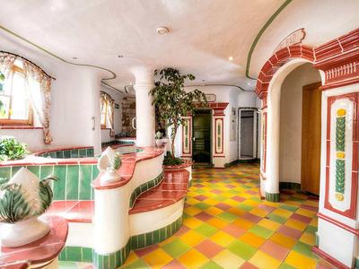 Hall d'hôtel coloré avec colonnes décorées, bancs et fenêtre avec lumière du jour