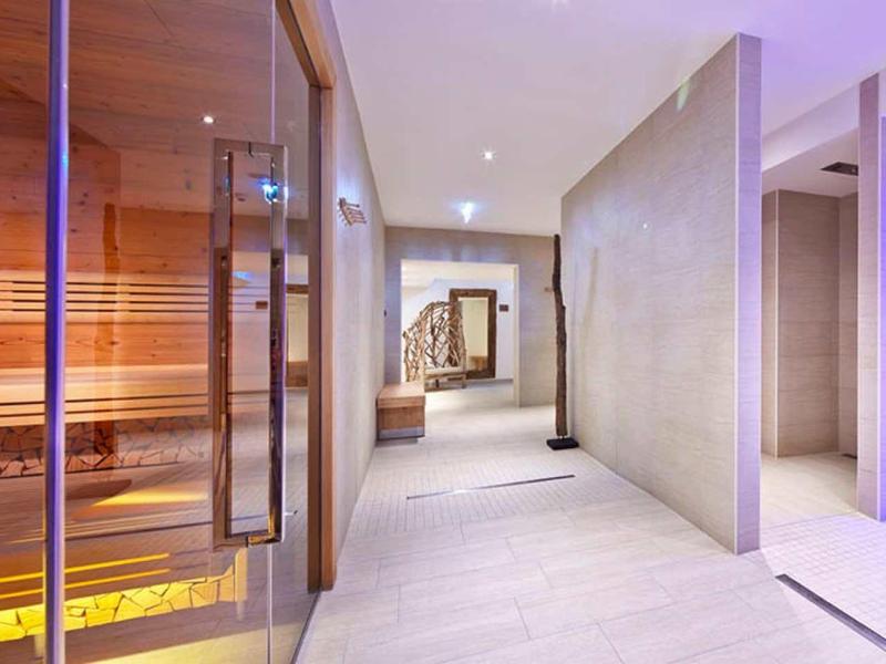 Area benessere moderna con sauna, corridoio tranquillo e luci rilassanti.