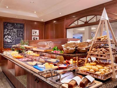 Buffet met een selectie van brood, vleeswaren en fruit in een elegant hotelrestaurant.