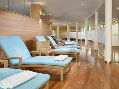 Ontspanningsruimte met blauwe ligstoelen en houten vloer in een hotel