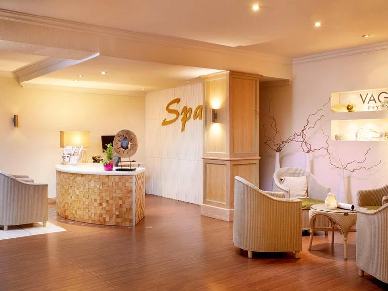 Elegante spa-receptieruimte met warme kleuren en comfortabele stoelen.