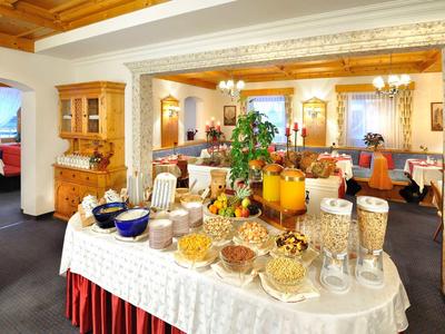 Buffet mit Müsli, Säften und Brot in einem gemütlichen Restaurant mit Holzakzenten.