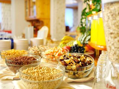 Buffet con cereali vari e succhi, disposto in modo accogliente e invitante.