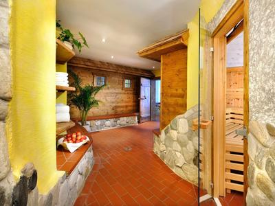 Accogliente zona benessere con sauna, piante e pareti in pietra in un hotel.