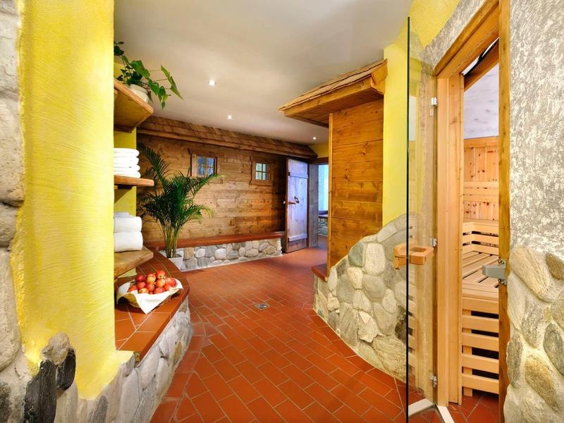 Accogliente zona benessere con sauna, piante e pareti in pietra in un hotel.