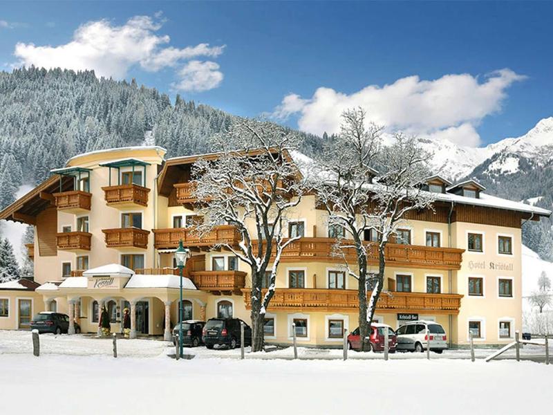 Hotel in un paesaggio montano innevato con cielo sereno e terreno coperto di neve.