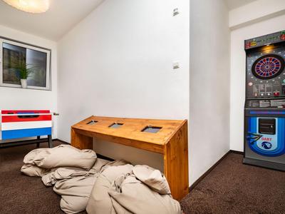 Spielzimmer mit Kickertisch, Dartscheibe und Sitzkissen in einem Hotel inneren Raum.