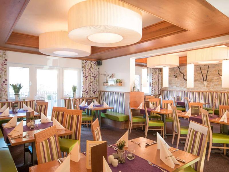 Jasna, przytulna restauracja z nowoczesnym drewnianym wystrojem i nakrytymi stołami, idealna dla gości.