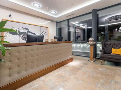 Réception moderne d'hôtel avec comptoir beige et coin salon confortable la nuit.