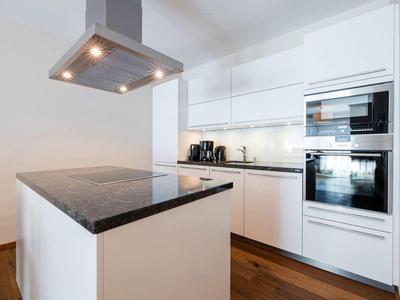 Modern white kitchen with black countertop and built-in appliances