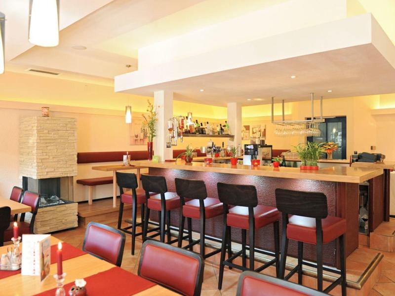 Světlý hotelový bar se stoličkami, stoly, židlemi a moderním osvětlením