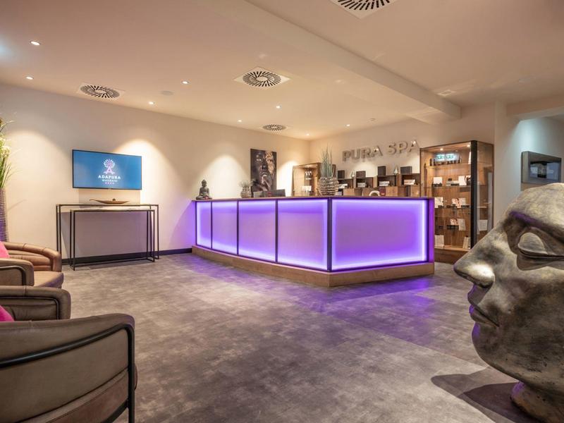 Modern reception area with illuminated counter and decorative sculpture head.