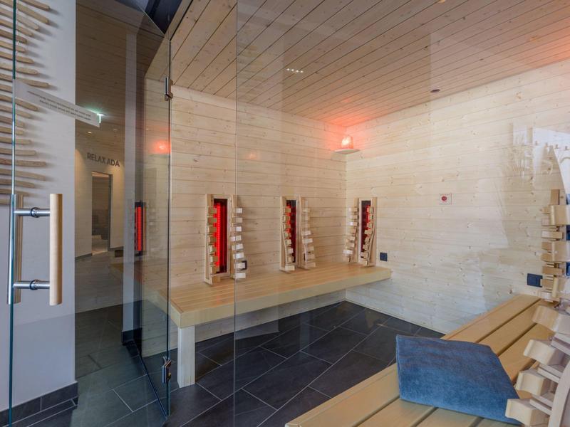Modern wellness area with saunas, benches, and a calm atmosphere.