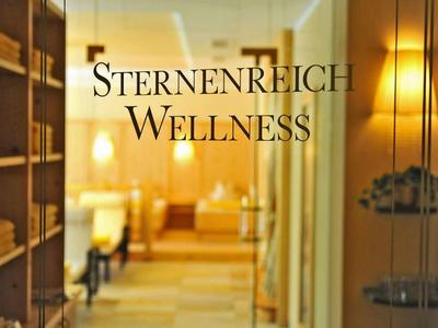 Einladender Wellnessbereich mit warmem Licht, Holzregalen und entspannter Atmosphäre, Schriftzug sichtbar.