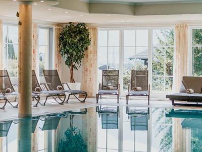 Innenpool mit Liegestühlen und großen Fenstern für viel Tageslicht.