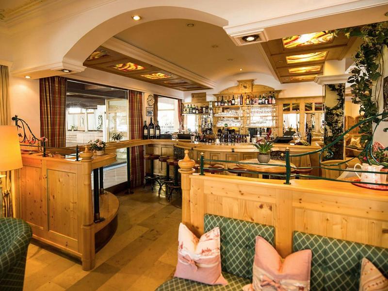 Gemütliche Restaurantinneneinrichtung mit Holzmöbeln, gepolsterten Sitzbänken und warmem Licht.