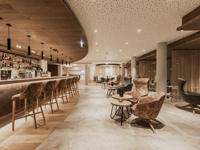 Elegante Hotelbar mit bequemen Sesseln und warmem, einladendem Licht.