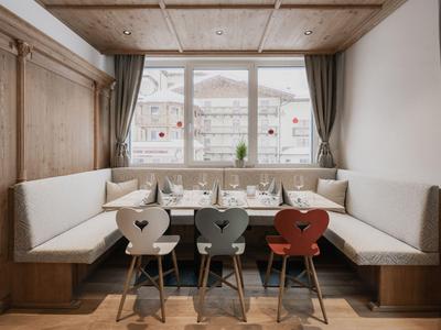 Gemütliche Sitzecke mit Holzdetails und Herzstühlen vor einem großen Fenster.